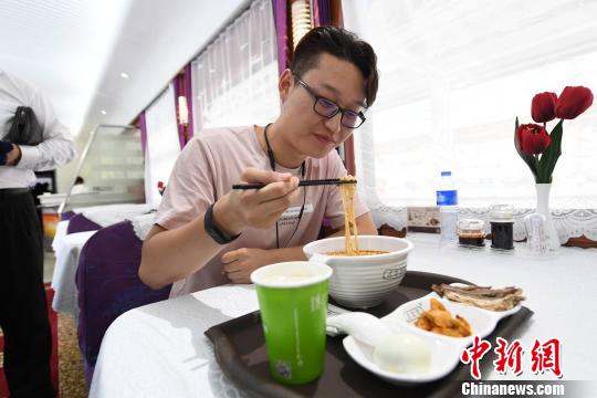 图为旅客在列车上享用正宗牛肉面?！⊙钛廾?摄