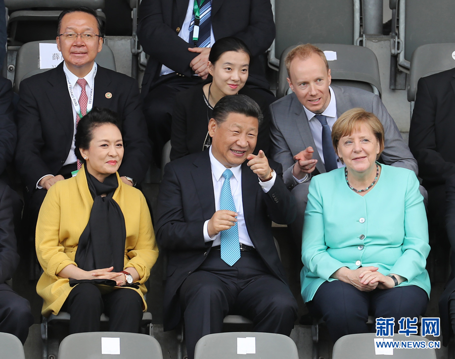 7月5日，国家主席习近平在柏林同德国总理默克尔共同观看中德青少年足球友谊赛。这是习近平和夫人彭丽媛同默克尔在看台上。 新华社记者 王晔摄